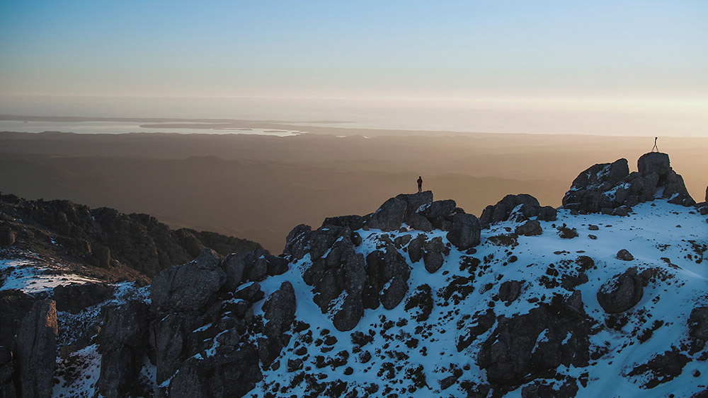Distant shot of someone standing at the peak of Mount Owen in Tasmania
