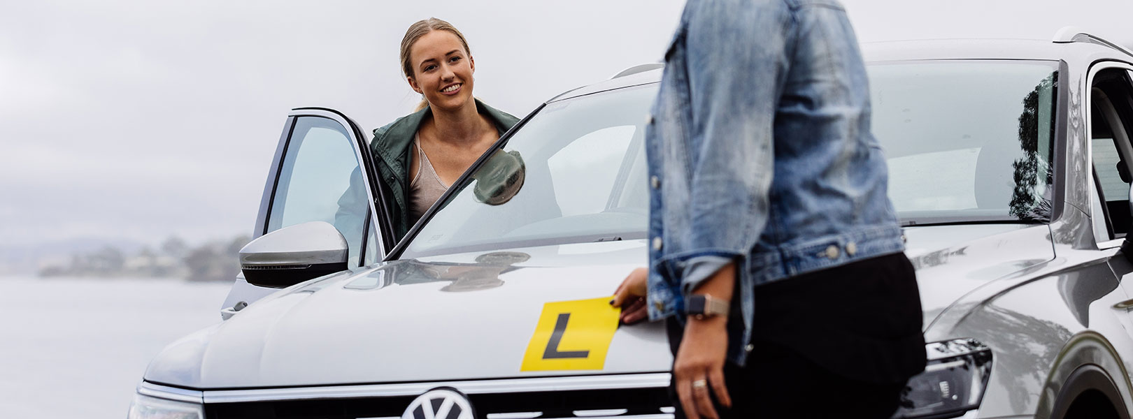 Young lady getting into the driver's seat of a car with L Plates displayed
