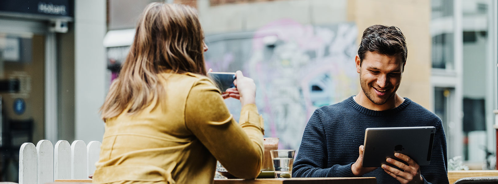 Man and woman in cafe looking at iPad.