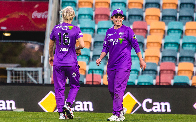 Corinne Hall and player on cricket ground