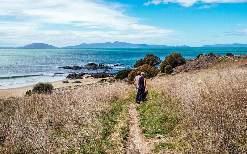 Two people walking on track down to Spiky Beach