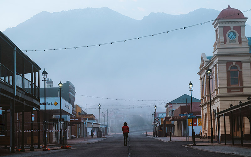 Lady standing in middle of deserted street in foggy Queenstown