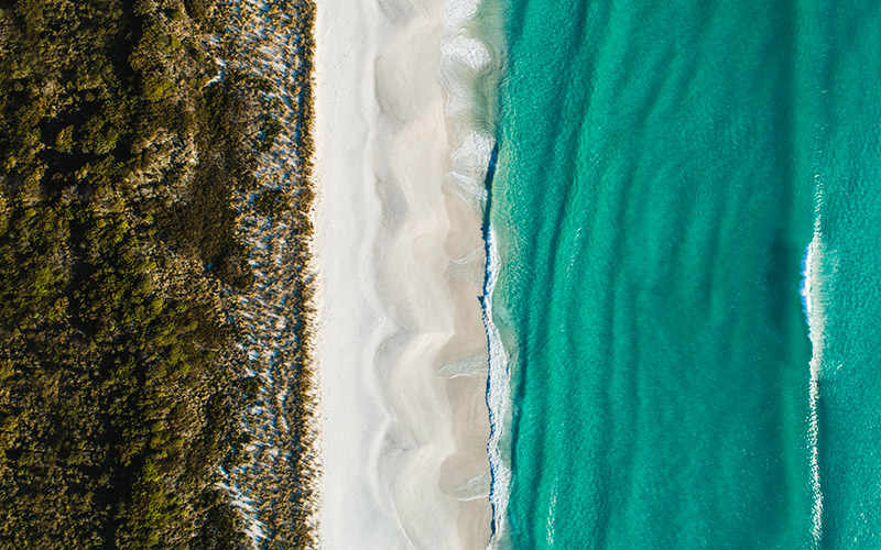 Ariel shot of water and beach at Bay of Fires