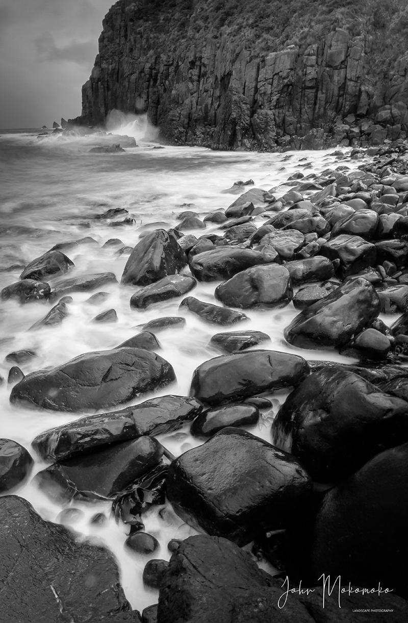 Black and white photo of rocks, ocean and cliffs o Bruny Island