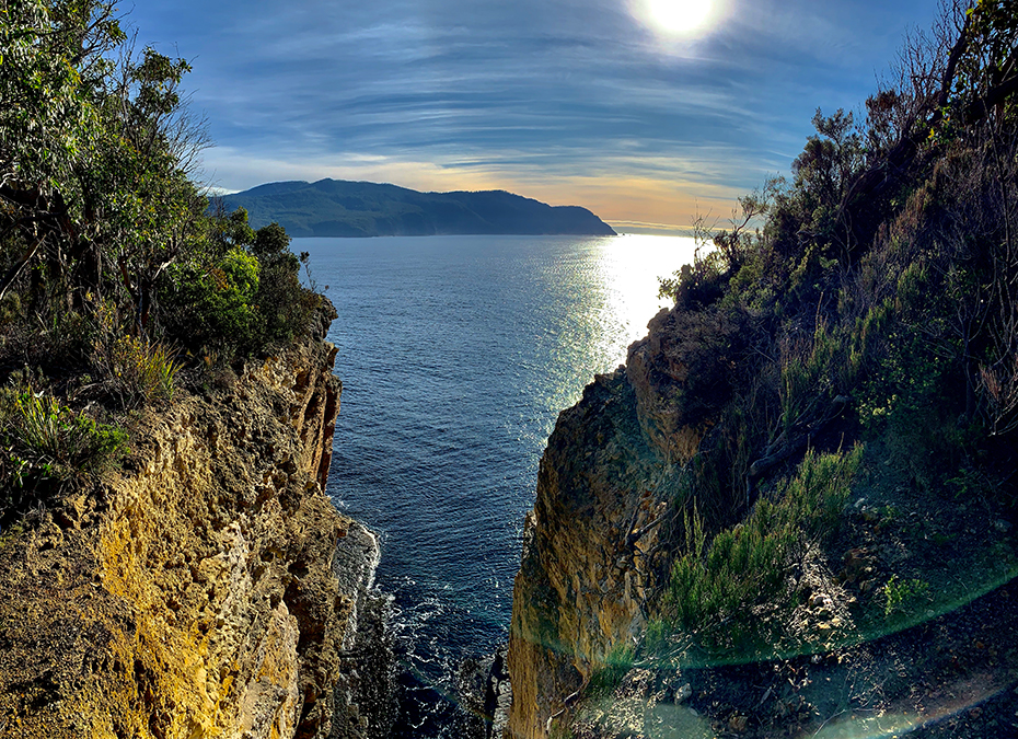 Sun over cliffs and the sea on the Tasman Peninsula