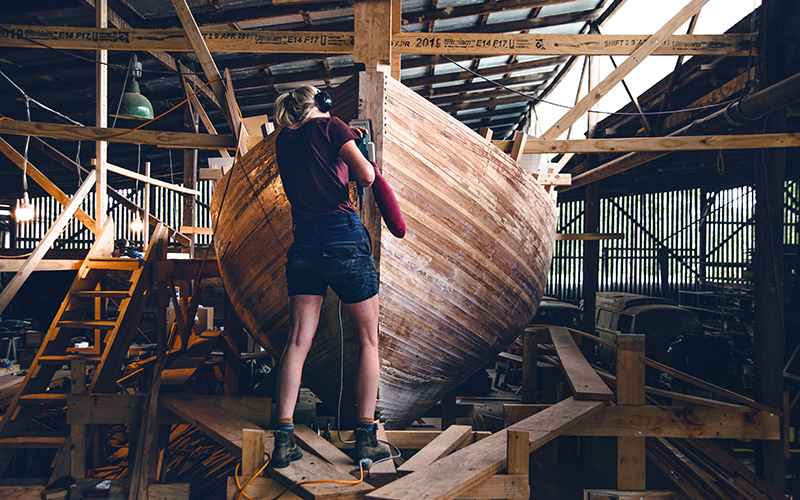 Person working on a wooden boat