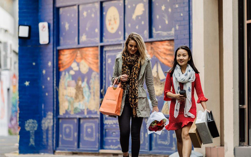 girls walking through town with shopping bags