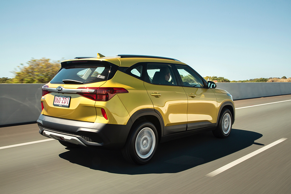 Yellow Kia Seltos driving on road