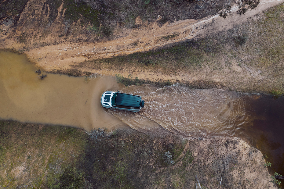 Landrover Defender driving through muddy water