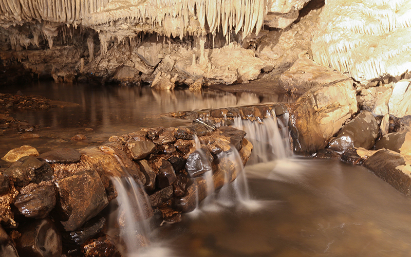 Inside Mole Creek Caves with running stream.