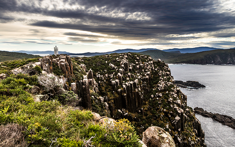 Cape Bruny Lighthouse and cliffs with moody sky.