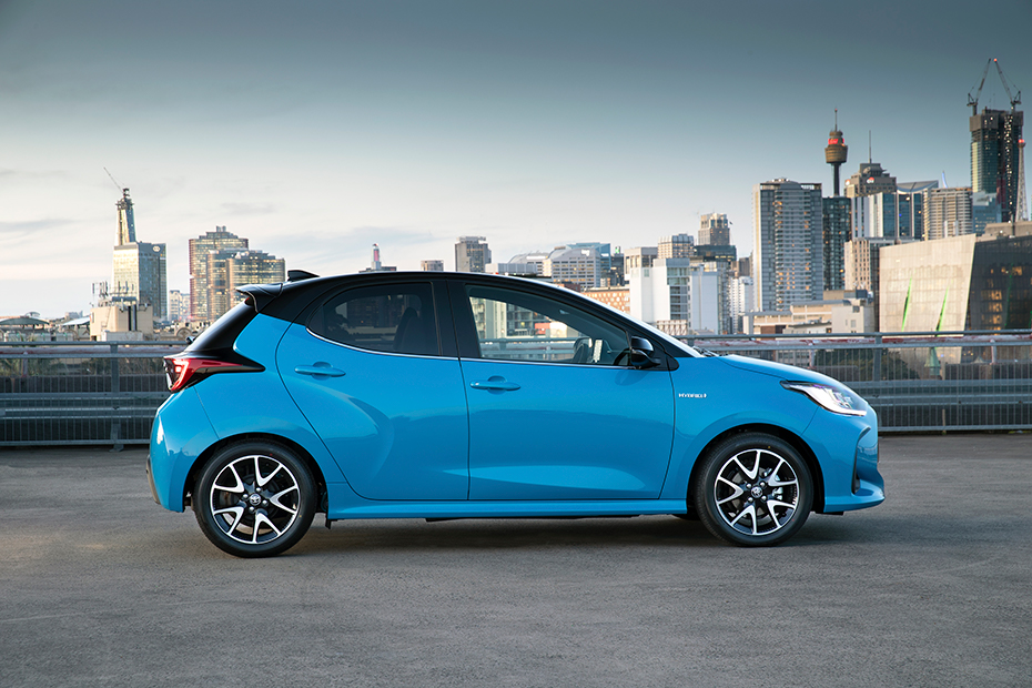 Blue Toyota Yaris Hybrid parked in front of city views