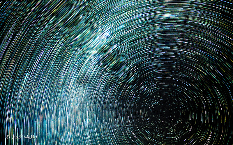 A blue and green circle of star trails