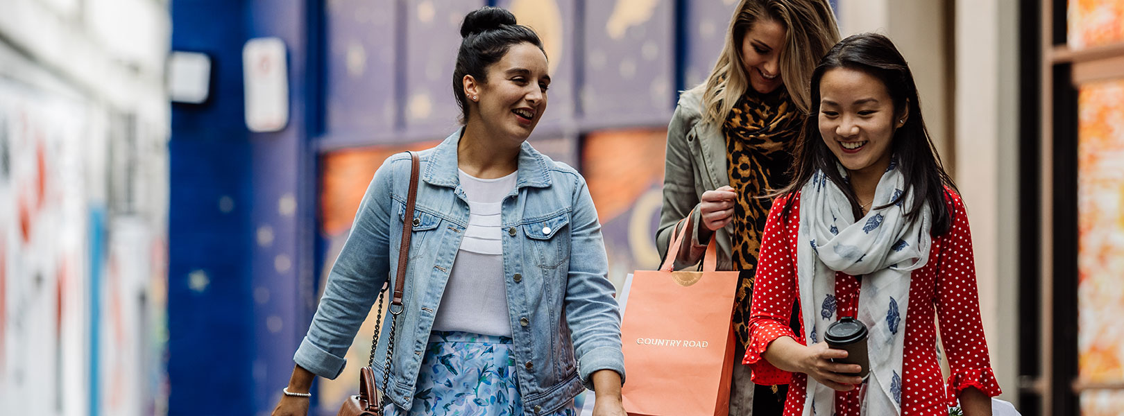 Girls chatting and walking down lane with shopping bags